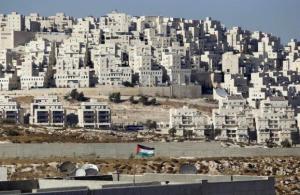 A Palestinian flag flutters in front of a Jewish settlement near Jerusalem
